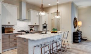 Magnolia Condo Kitchen with White Cabinets and Counter Tops with Bar Stools